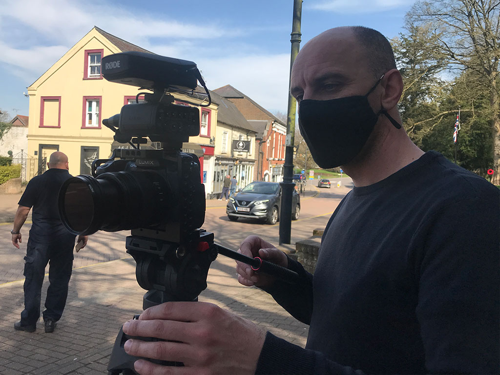 Videographer using camera on a high street