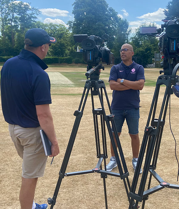 filming an interview on a cricket ground