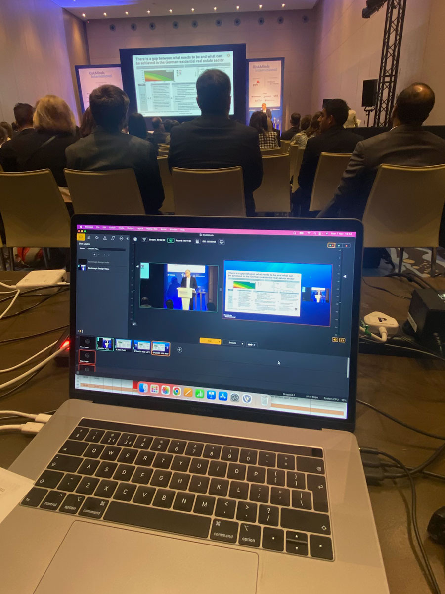 Laptop on. a desk live-streaming speech at conference